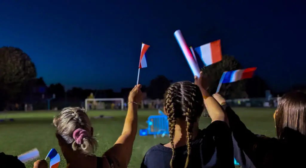 3 Femmes de dos avec des drapeaux français la nuit
