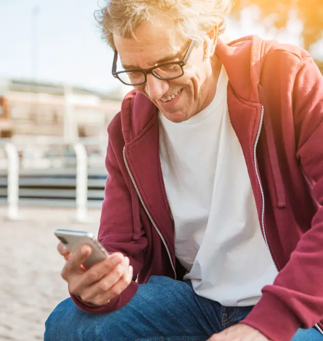Un homme assis regardant son téléphone