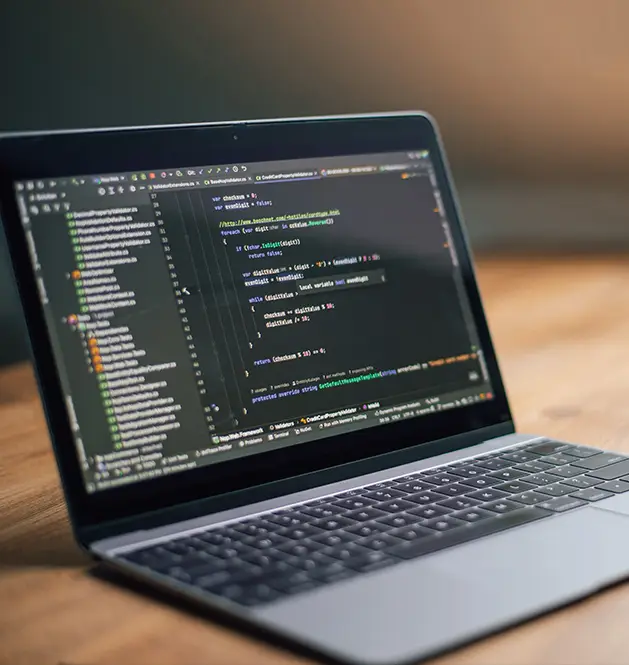 Ordinateur portable affichant du code sur un bureau en bois